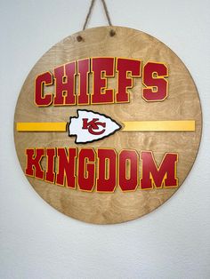 a wooden sign that says chiefs kingdom with a football helmet on it and the words chiefs kingdom