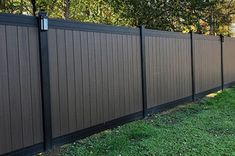 a dog is standing in the grass near a fence