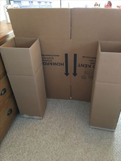 two cardboard boxes sitting on the floor with arrows pointing to each other in front of them