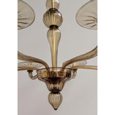 a chandelier with five lights hanging from it's sides and three shades of gold