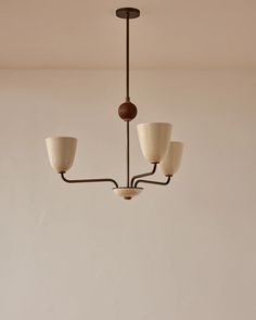 a chandelier with five lights hanging from it's sides in a room