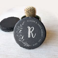 a small potted plant sitting on top of a rock with the letter r in it