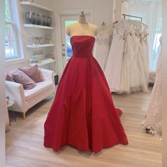 a red dress on display in a bridal shop