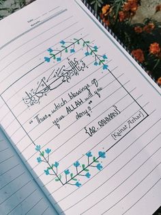 an open notebook with writing on it and some flowers in the backgroung