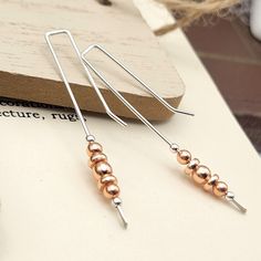 "These beautiful Long Silver & Copper Threaders will upgrade any look! Featuring long silver threader earrings with copper beads, these earrings are perfect for making a statement without breaking the bank! Make a splash and add some color and length to your jewelry collection. * Approximately 2\" long * Earrings are made from quality Sterling Silver wire and Copper * Polished to a high shine * Sent in a Gift Box with Polishing Cloth ----- OUR MATERIALS -----  *STERLING SILVER - Experience the e Silver Threader Earrings, Copper Jewellery, Earring Ideas, Craft Jewelry, Earrings Long, Threader Earrings, Delicate Earrings, Modern Earrings, Wire Earrings