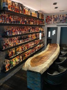 a wooden table sitting in front of a wall filled with bottles and liquors on shelves