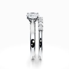 two wedding rings with black and white diamonds on each side, set in 18k white gold