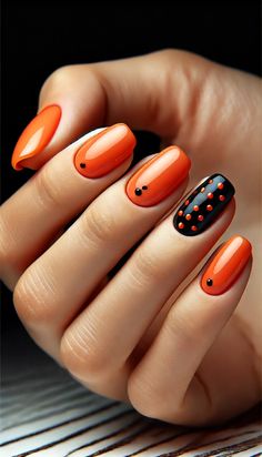 Add a splash of retro charm to your look with these chic orange nails featuring a glossy finish and tiny black polka dots. Perfect for anyone who loves a playful yet elegant nail art style. Explore this trendy design and get inspired to create your own statement nails. #NailArt #PolkaDotNails #OrangeNails #RetroStyle #ChicNails Easy Fingernail Designs, Orange And Black Nail Ideas, Swag Nails Designs, Black Orange Nails, Orange Trendy Nails, Black And Orange Nail Designs, Orange Black Nails, Orange And Black Nail Designs, Short Orange Nails