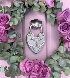 a wreath with purple roses and a metal padlock