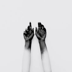 two hands with black and white paint on them