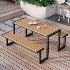 a table and bench on a wooden deck with flowers in the potted planter