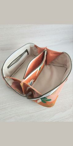 an orange and white purse sitting on top of a wooden table