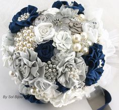 a bridal bouquet with blue, white and grey flowers on it's side