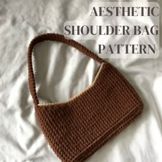 a crocheted shoulder bag sitting on top of a white bed with the words aesthetic shoulder bag pattern