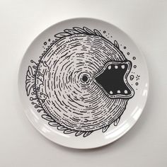 a black and white plate with an image of a fish on it