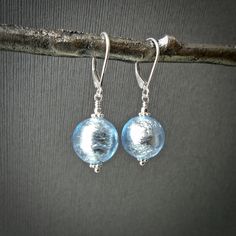 "⇩CLICK BELOW FOR DETAILS⇩ ✦These brilliant Italian glass Venetian bead earrings have magnificent aquamarine blue round beads measuring 12mm in diameter. Each Murano glass Venetian bead has a foil interior to create a stunning look. These beautiful beads are accented with silver daisy spacers. Earring length is approximately 1.3 inches. ✦Earrings come with sturdy, secure, and easy to wear sterling silver hook or lever back ear wires. Please select at check out. ✦Also available in yellow gold htt Czech Glass Round Jewelry Gift, Round Czech Glass Jewelry Gift, Elegant Round Glass Earrings, Light Blue Round Bead Earrings For Gift, Nickel-free Light Blue Round Bead Jewelry, Elegant Hypoallergenic Glass Jewelry, Nickel-free Murano Glass Jewelry For Gifts, Nickel-free Murano Glass Jewelry Gift, Hypoallergenic Round Glass Jewelry