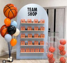 basketballs and balloons are displayed in front of a team shop display