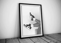 a black and white photo of a pair of shoes on the floor next to a framed photograph