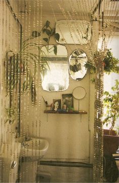 the bathroom is decorated with plants and mirrors