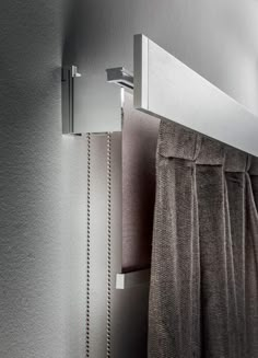 the curtain is hanging on the wall next to the shower head and hand towel rack