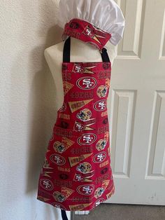 a red apron with the san francisco giants on it and a white chef's hat