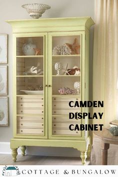 a green cabinet with shells on it and the words camden display cabinet