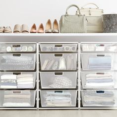 the closet is organized with clear bins and plastic containers for clothing, shoes, and handbags