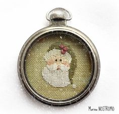 a close up of a pocket watch on a white surface with an image of santa claus