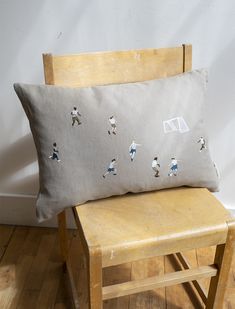 a chair with a pillow on top of it and a basketball game embroidered on the back