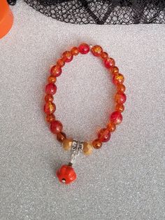 Halloween Beaded Bracelet, No Clasp. Slips On and Off the wrist. Red and Orange with Pumpkin Charm. Comes with Storage Bag. Halloween Beads, Orange Pumpkin, Red And Orange, Pumpkin Orange, Wedding Shop, Storage Bag, Beaded Bracelet, Bag Storage, Beauty Book