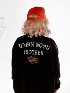 the back of a person wearing a black sweatshirt with white writing on it and a red hat