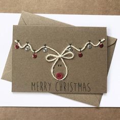 a christmas card with a reindeer's head and lights on it, tied in twine