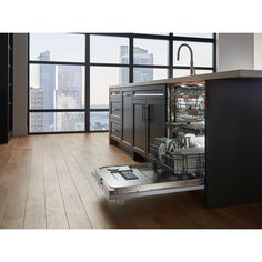 an empty dishwasher is in the middle of a room with large windows and wooden floors