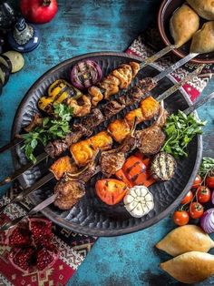 several skewers of meat and vegetables on a plate