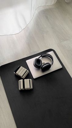 a pair of headphones sitting on top of a mouse pad next to two rectangles