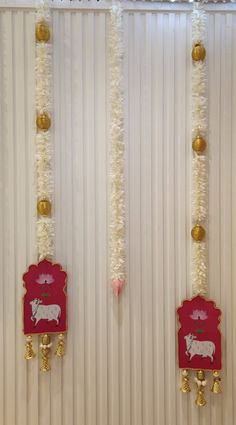 the wall is decorated with white flowers and gold bells, along with two red plaques