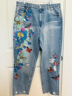 a pair of jeans with butterflies and flowers on them