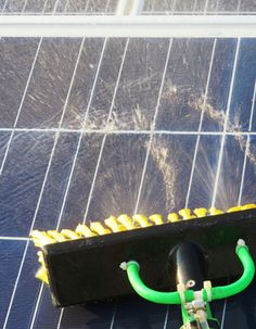 a black and yellow umbrella sitting on top of a blue tile floor next to a solar panel