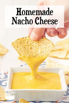 homemade nacho cheese being dipped into a bowl with tortilla chips on the side