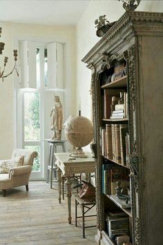 a living room filled with furniture and a large book case in front of a window