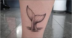 a tattoo on the leg of a person with a whale tail