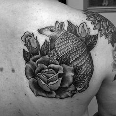 a man with a fish and rose tattoo on his back