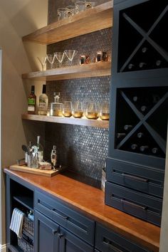 a kitchen counter with wine glasses on it and shelves in the backround area