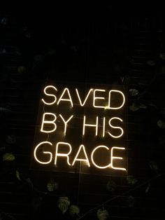 a neon sign that says saved by his grace