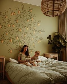 a woman sitting on top of a bed next to a child