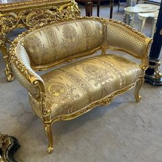 an ornately decorated gold couch in a room filled with other antique furniture and antiques