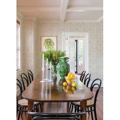 a dining room table with chairs and vases on it