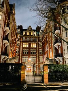 the entrance to an apartment building at night with lights shining on it's windows