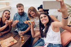 group of friends eating pizza and drinking beer together