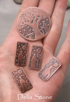 five different types of metal buttons in the palm of someone's hand, with an image of jesus and mary on it